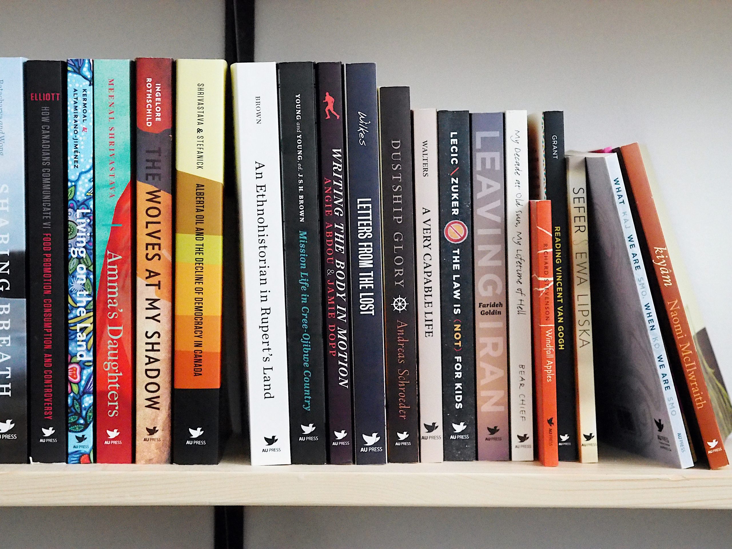 a shelf with book published by AU Press